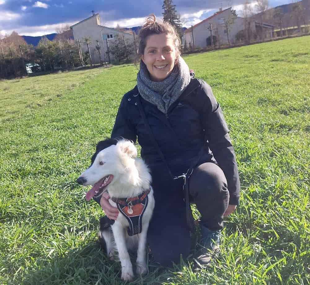 Éducatrice canin souriante aux côtés de son chien